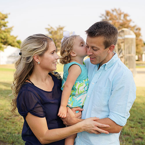 A man of wife holding their daughter