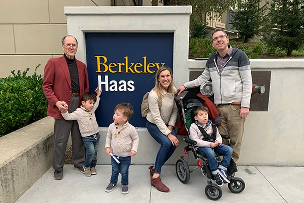 Kate Mansalis poses with family in front of Berkeley Haas sign